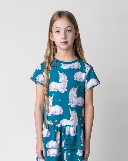 Close up of the Daydreaming Unicorn Dress in teal on a kid, front view