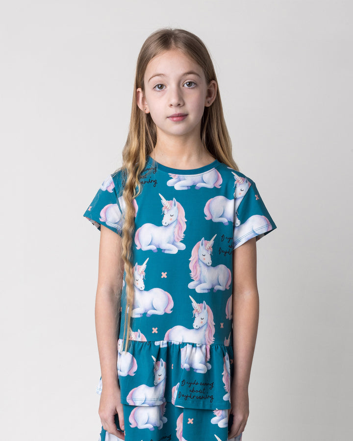 Close up of the Daydreaming Unicorn Dress in teal on a kid, front view