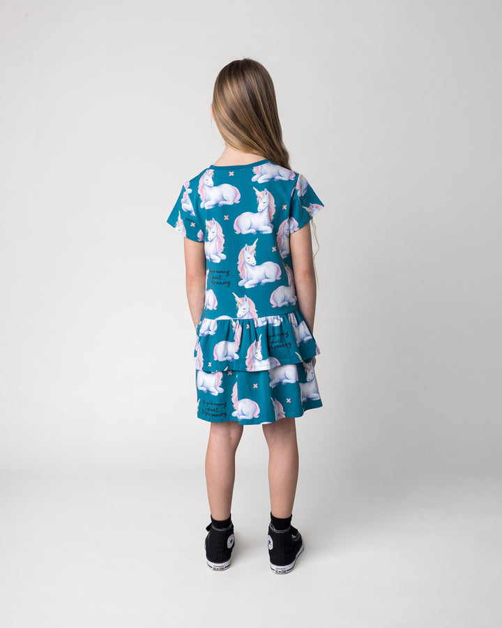 Kid wearing the Daydreaming Unicorn Dress in teal, back view