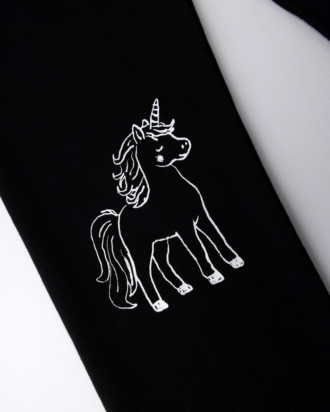 Close up of the Hello Unicorn Tights print in black
