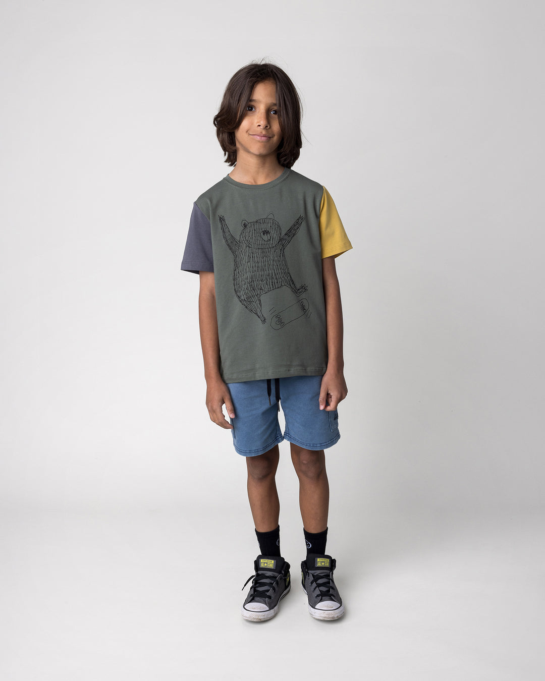 Kid wearing the Boarding Bear Tee in forest, dark grey and yellow with the Blasted Deluxe Cargo Short in midnight wash, front view