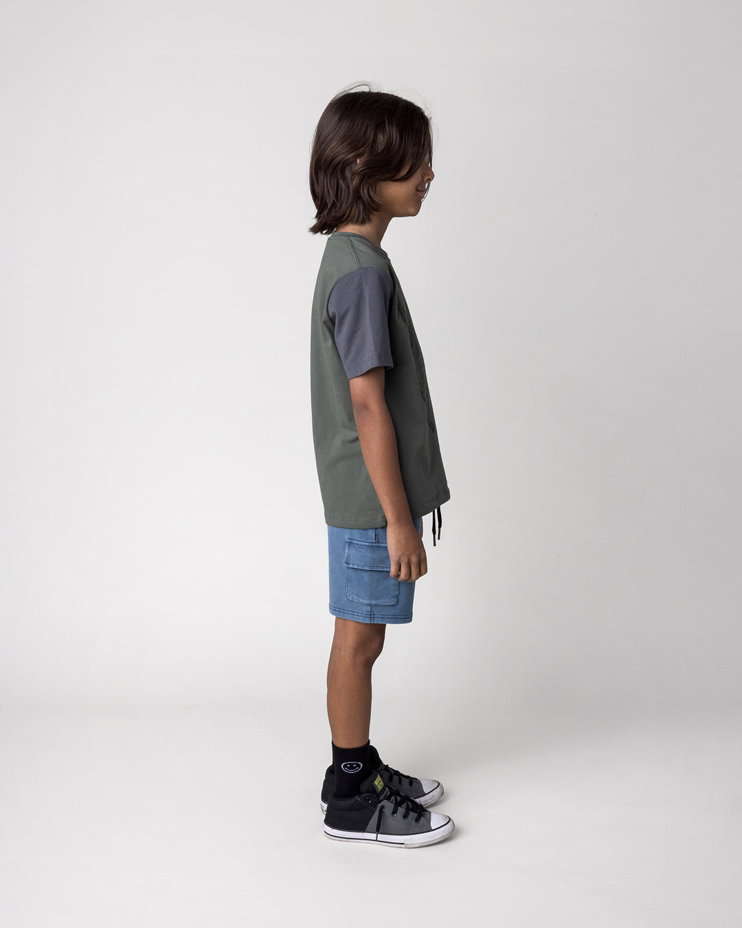 Kid wearing the Boarding Bear Tee in forest, dark grey and yellow with the Blasted Deluxe Cargo Short in midnight wash, side view