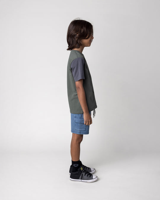 Kid wearing the Boarding Bear Tee in forest, dark grey and yellow with the Blasted Deluxe Cargo Short in midnight wash, side view