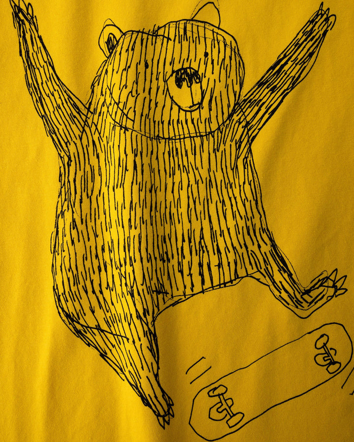 Close up of the Boarding Bear Tee print in mustard