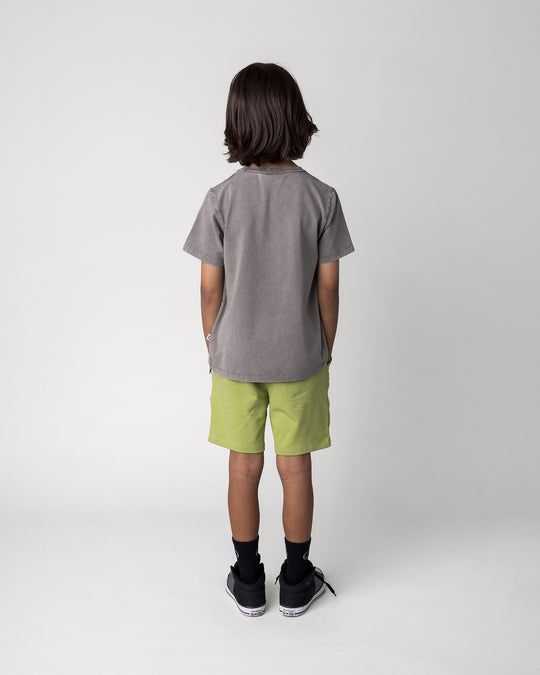 Kid wearing the Cool Crew Tee in grey wash with the Track Short in lime, back view