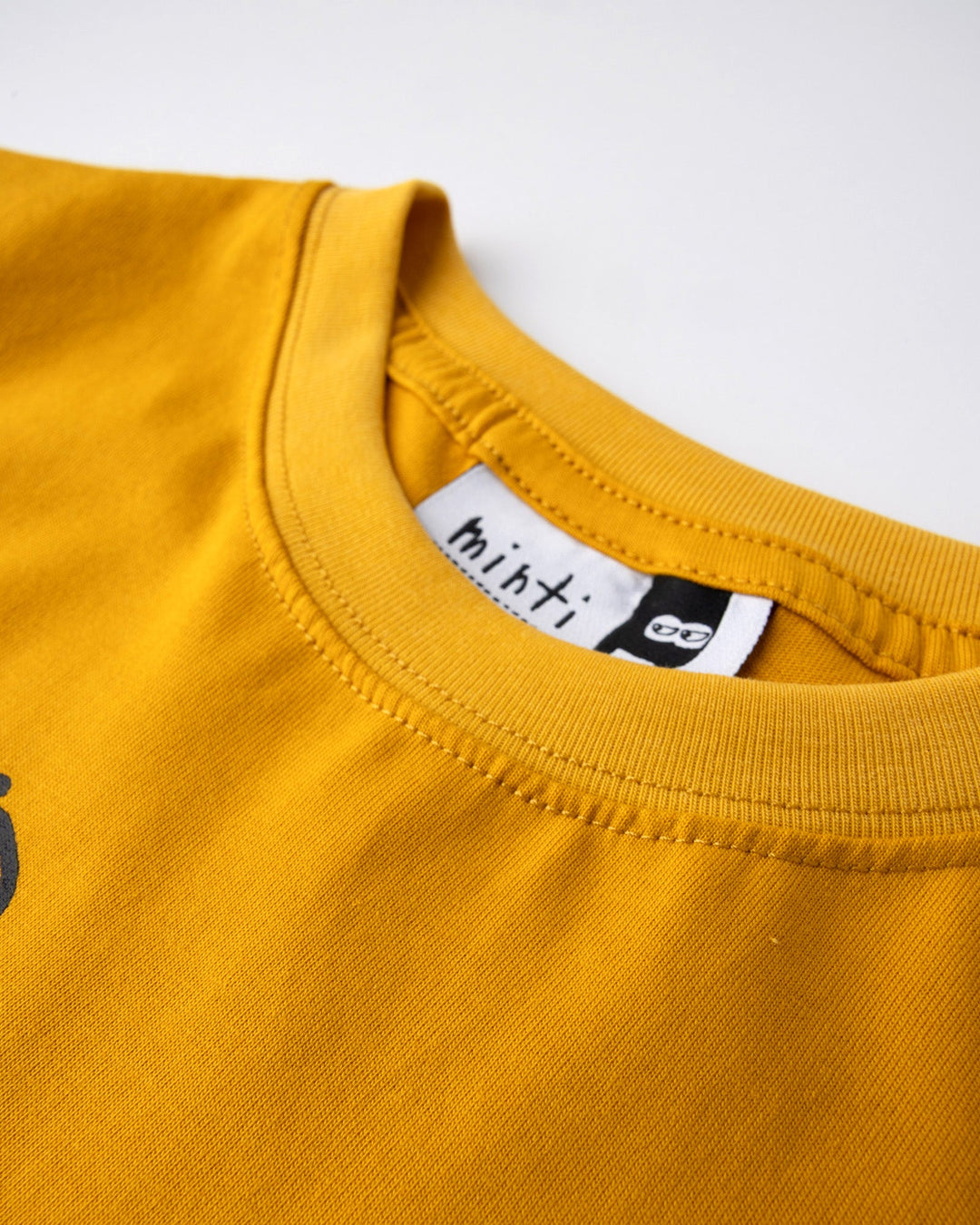 Close up detail of the Cool Crew Tee in mustard, midnight and orange