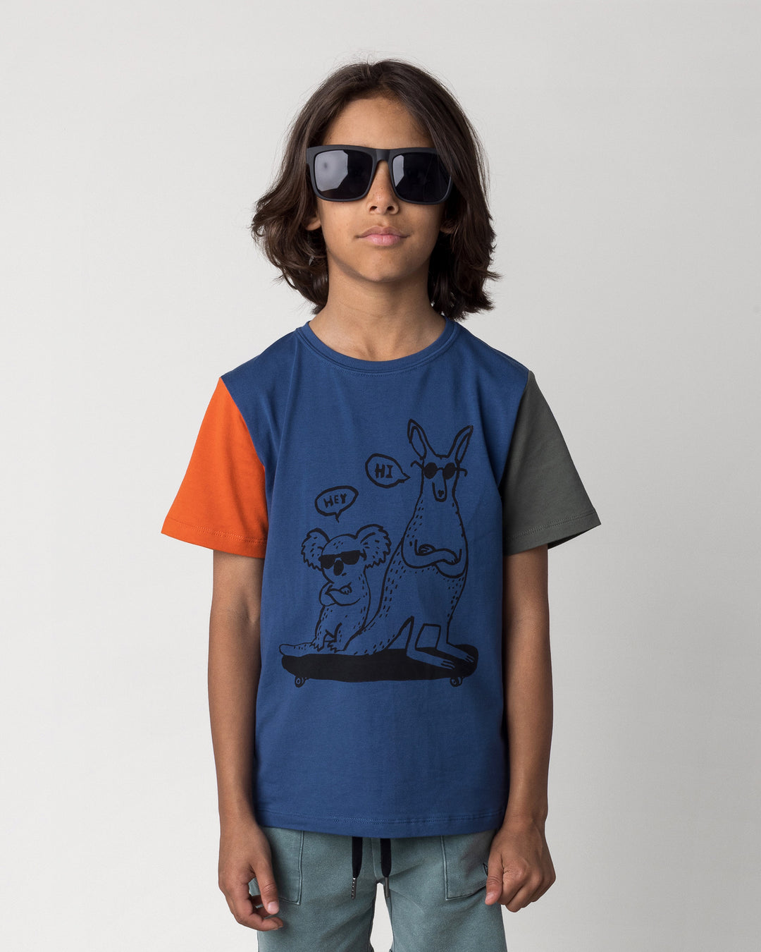 Close up of the Chill Mates Tee in midnight, orange and forest on a kid, front view