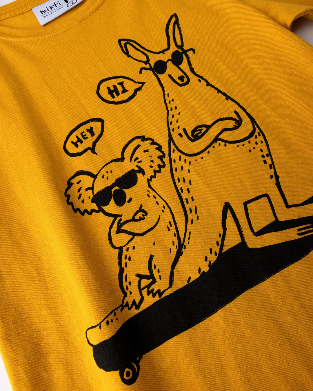 Close up of the Chill Mates Tee print in mustard