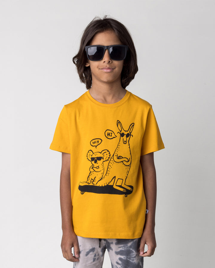 Close up of the Chill Mates Tee in mustard on a kid, front view