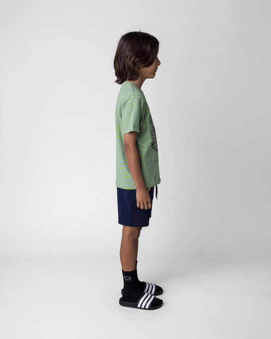 Kid wearing the Chill Sloth Tee in lime stripe with the Badges Short in ink, side view