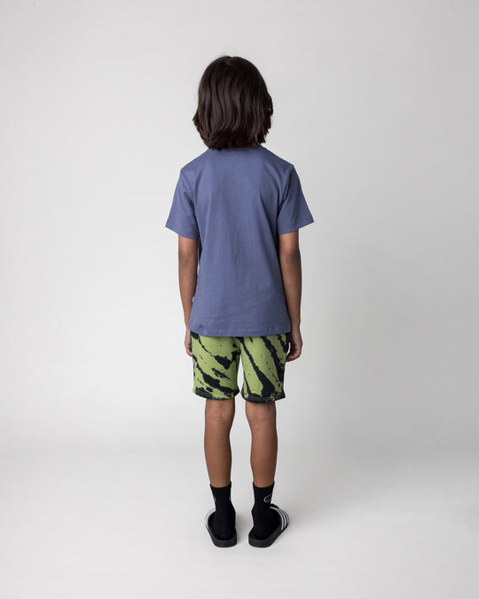 Kid wearing the Chill Sloth Tee in muted blue with the Strike Short in lime, back view