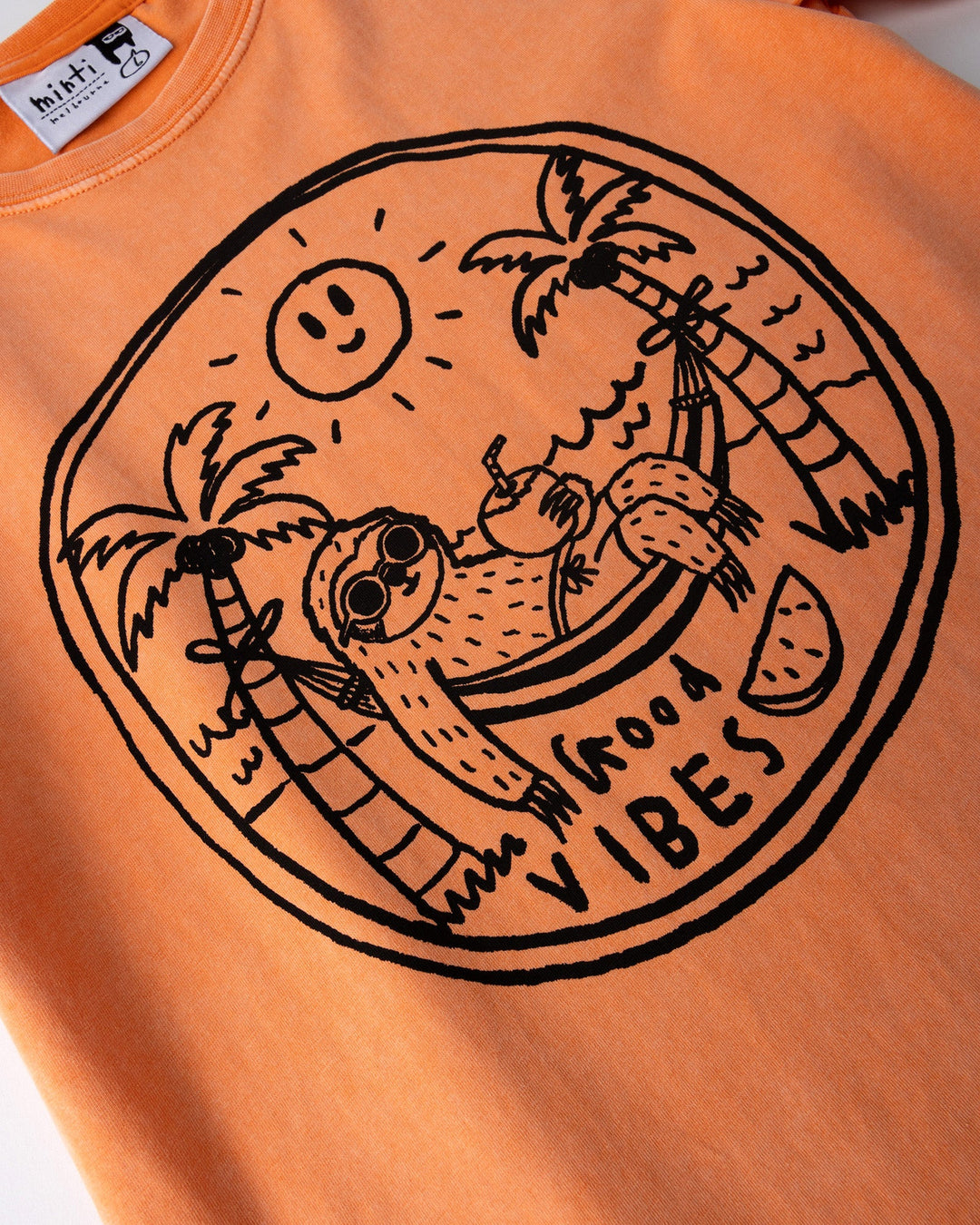 Close up of the Chill Sloth Tee print in orange wash