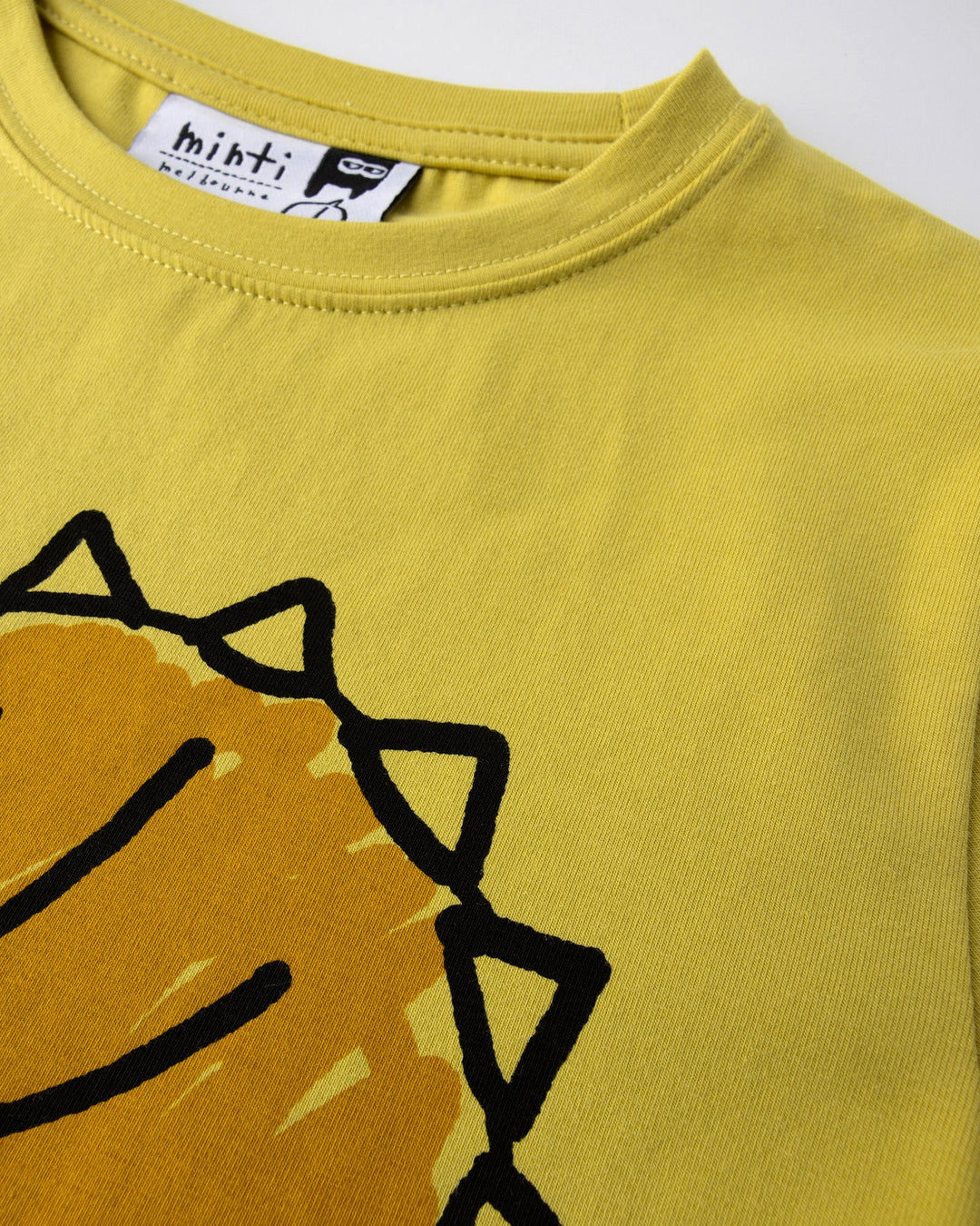 Close up of the Cool Dino Tee print in zest