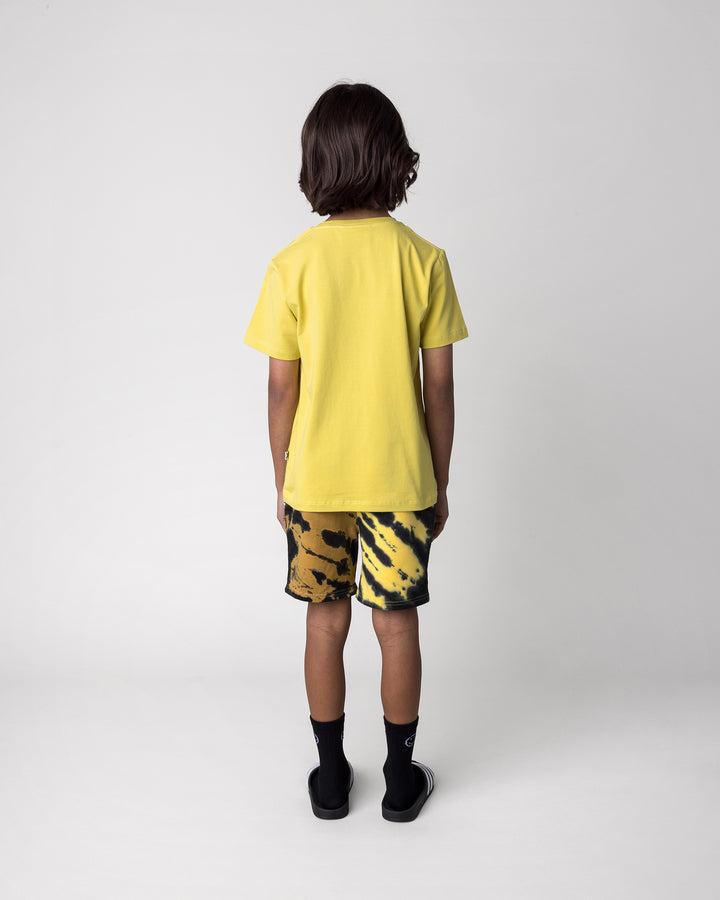 Kid wearing the Cool Dino Tee in zest with the Duo Tie Dye Short in lemon and rust, back view