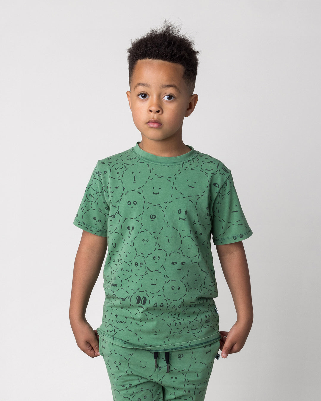 Close up of the Different Faces Tee in turf wash on a kid, front view