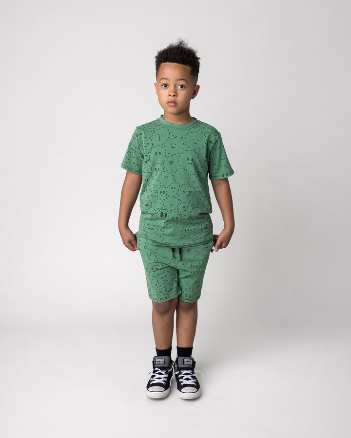 Kid wearing the Different Faces Tee in turf wash with the Different Faces Short in turf wash, front view
