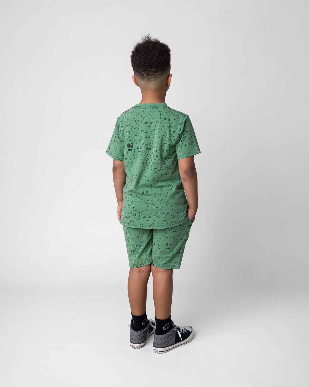 Kid wearing the Different Faces Tee in turf wash with the Different Faces Short in turf wash, back view