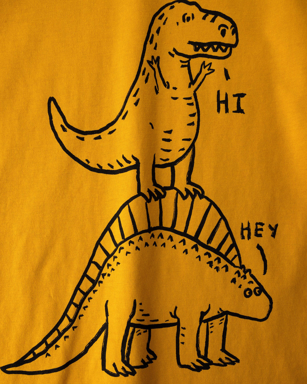 Close up of the Dino Ride Tee print in mustard, grey and orange