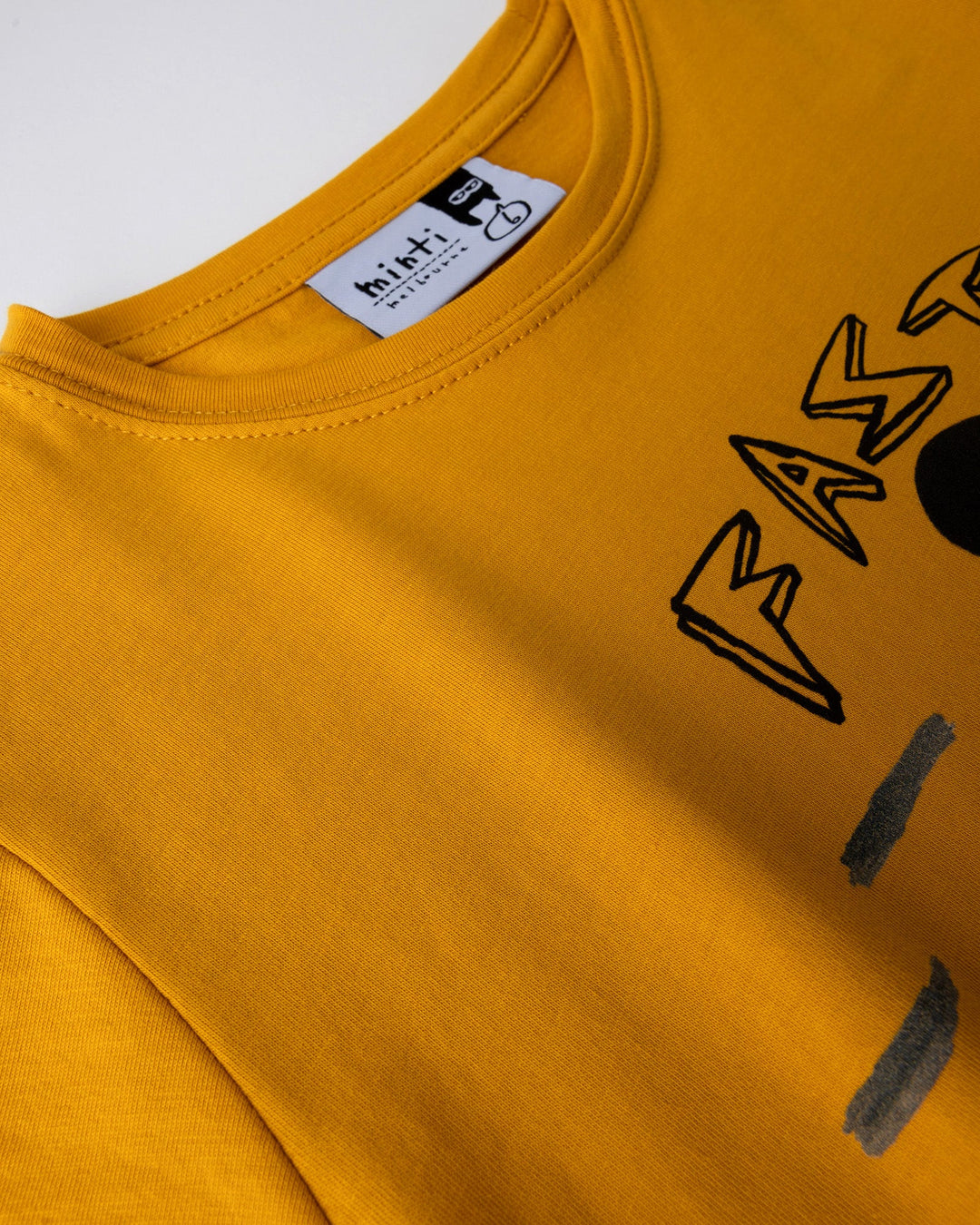 Close up detail of the Fast Panda Tee in mustard