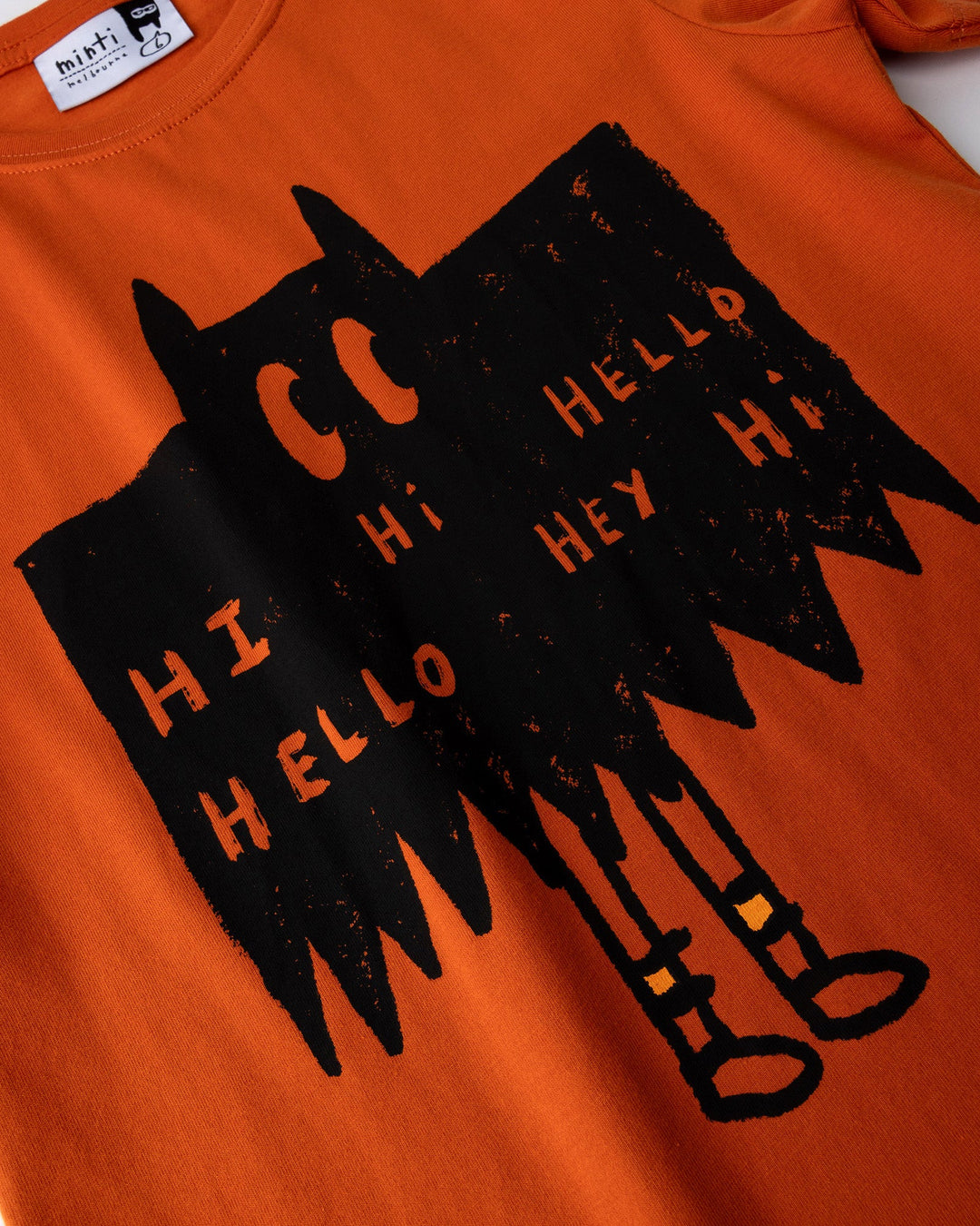 Close up of the Greetings Bat Tee print in orange