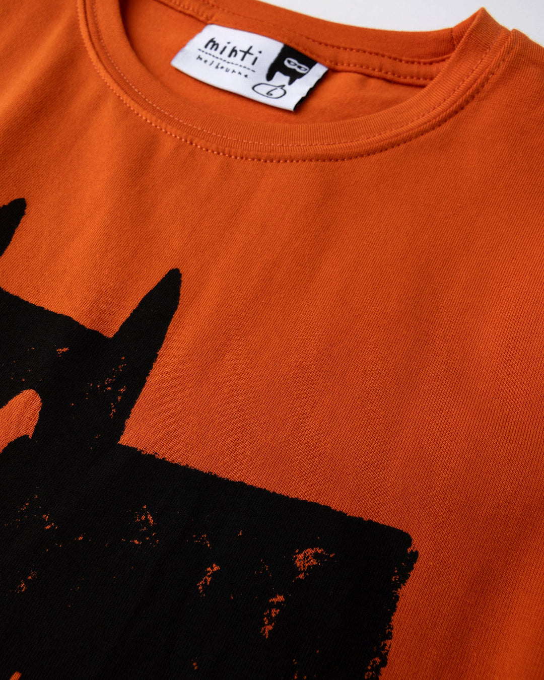 Close up of the Greetings Bat Tee print in orange