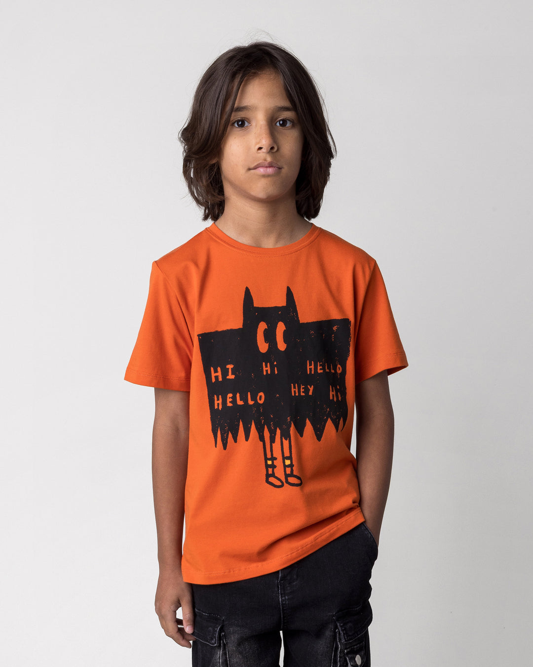 Close up of the Greetings Bat Tee in orange on a kid, front view