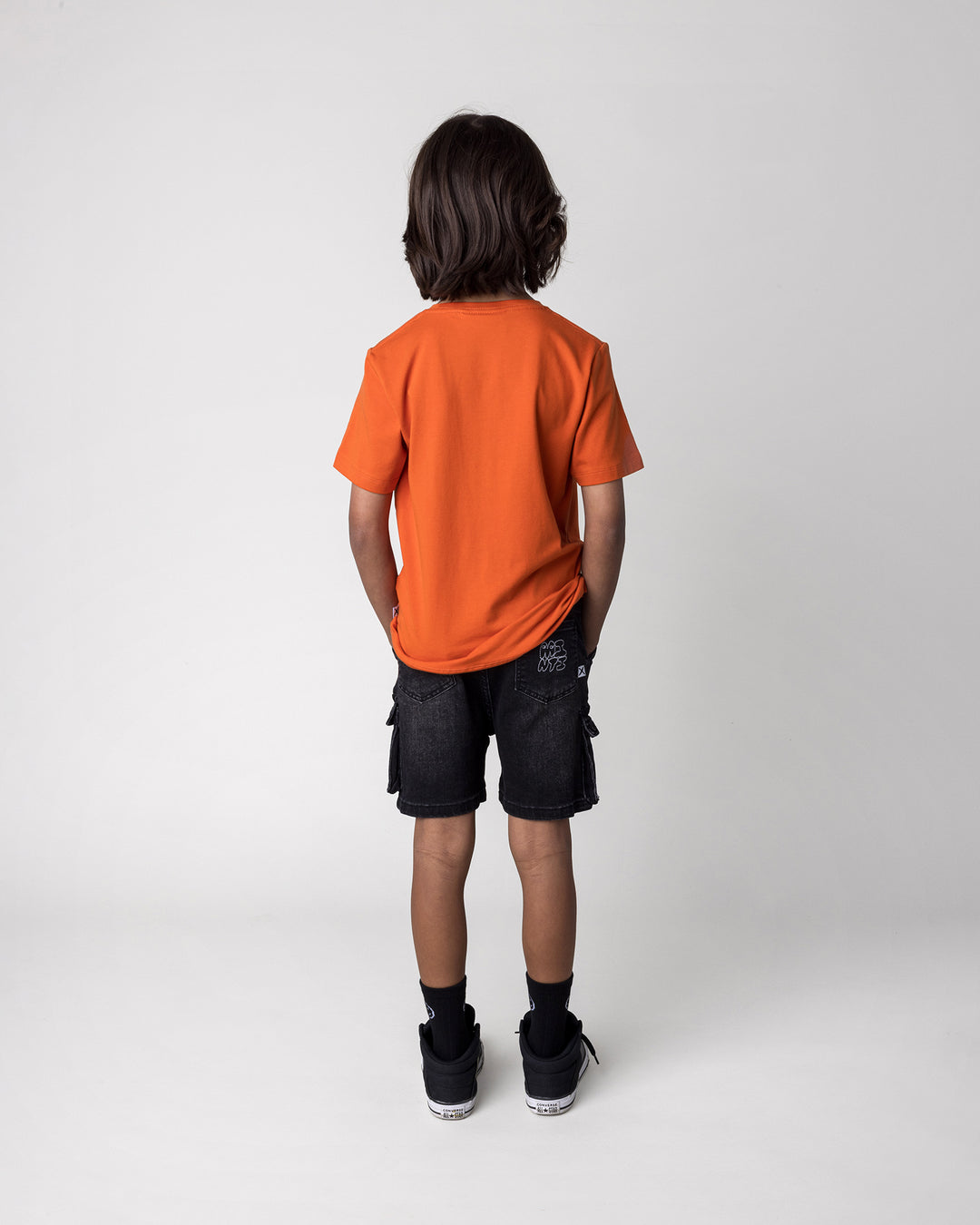 Kid wearing the Greetings Bat Tee in orange, back view