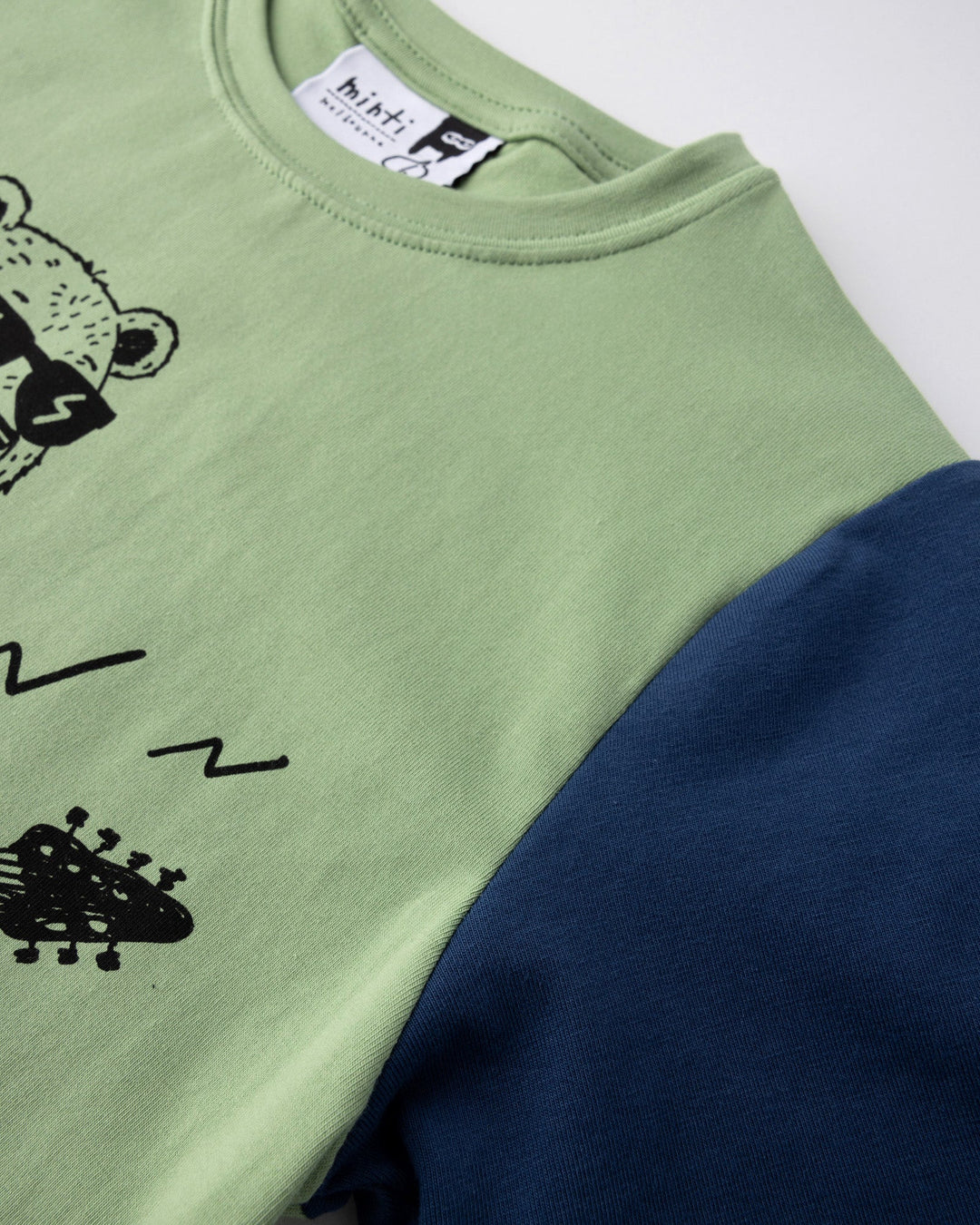 Close up detail of the Grizzly Tee in sage, yellow and midnight