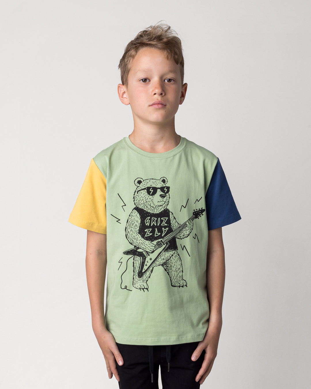 Close up of the Grizzly Tee in sage, yellow and midnight on a kid, front view