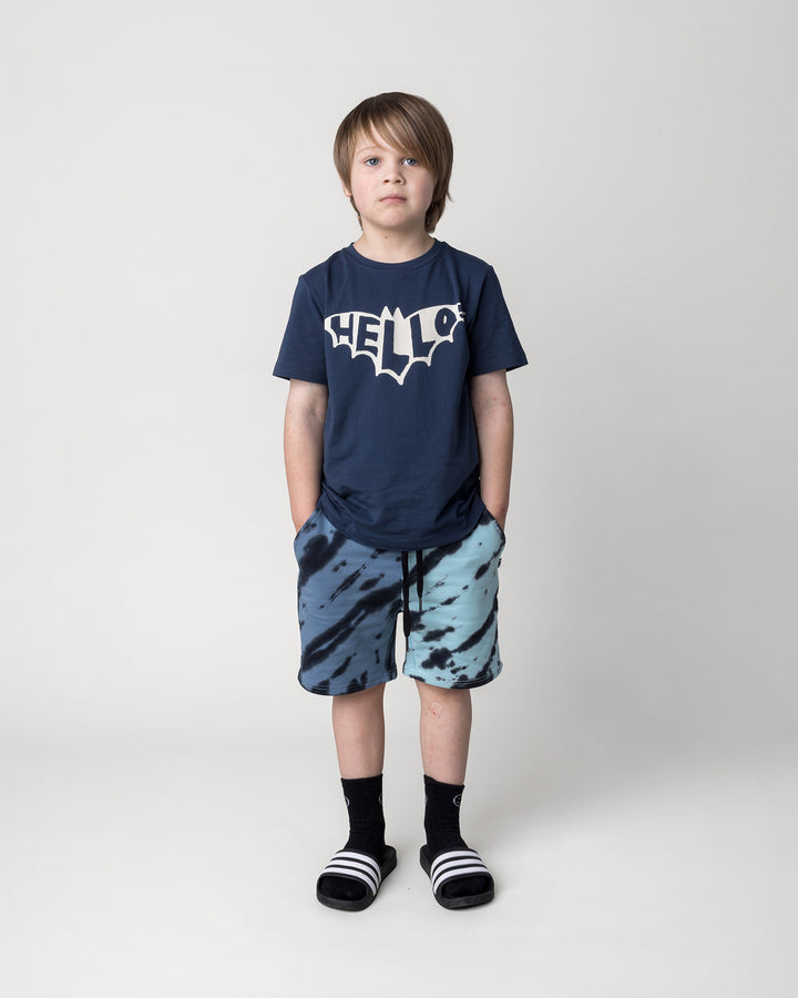 Kid wearing the Hello Bat Tee in ink with the Duo Tie Dye Short in blue and aqua, front view