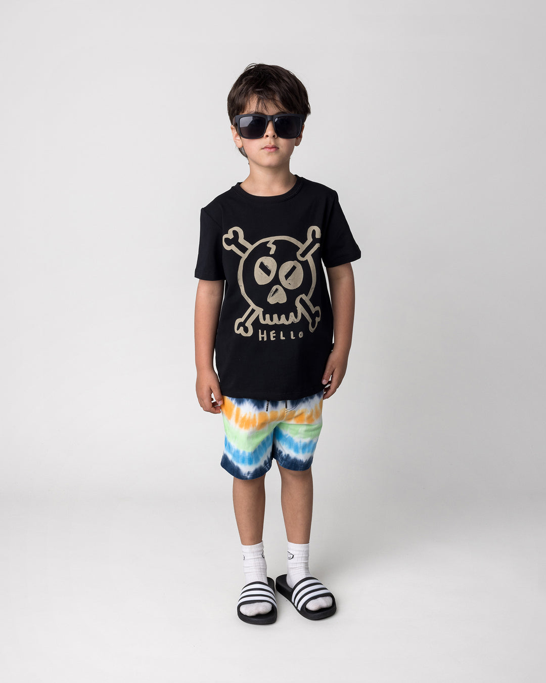 Kid wearing the Hello Skull Tee in black with the Airwaves Short in navy, front view
