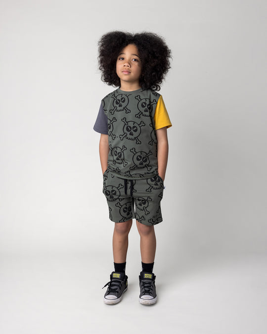 Kid wearing the Hello Skull Tee in forest, dark grey and yellow with the Hello Skull Short in forest, front view