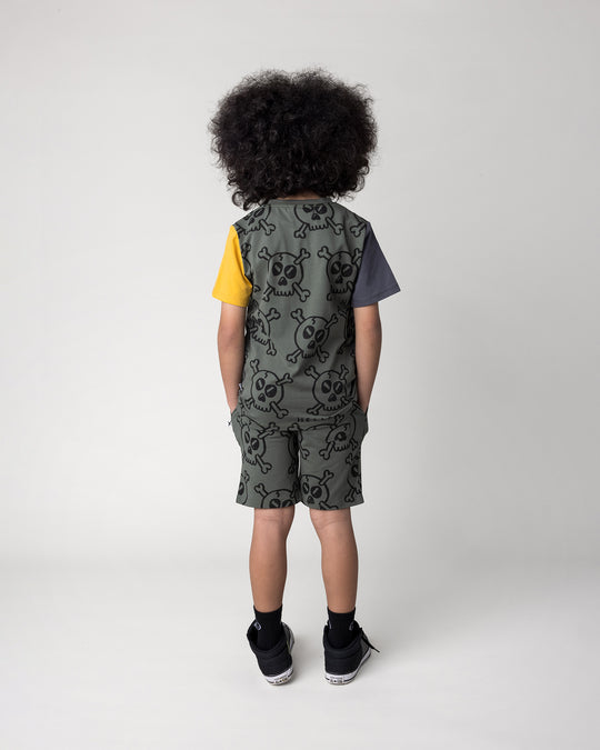 Kid wearing the Hello Skull Tee in forest, dark grey and yellow with the Hello Skull Short in forest, back view