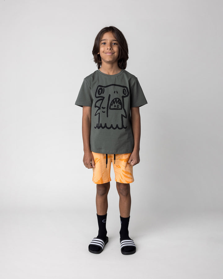 Kid wearing the Hi Hammerhead Tee in forest with the Splatter Short in orange, front view