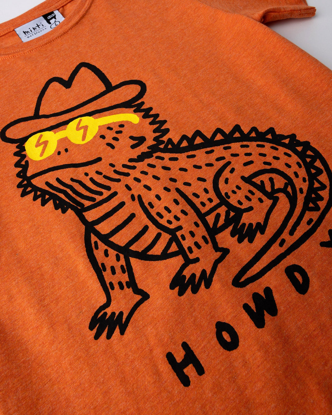 Close up of the Howdy Lizard Tee print in orange marle