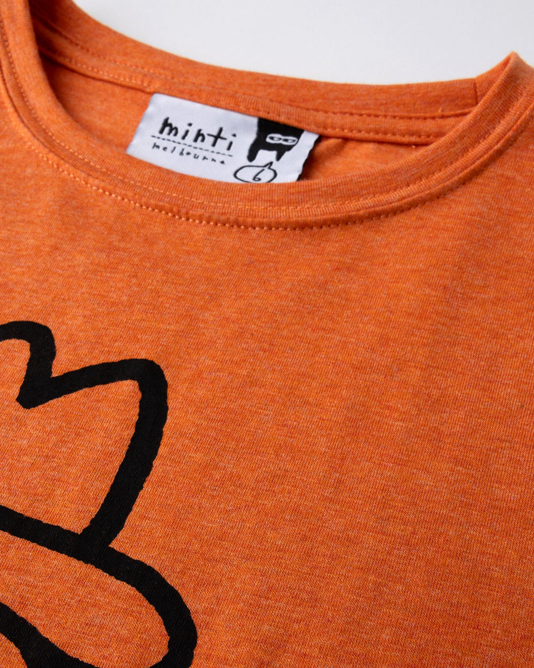 Close up detail of the Howdy Lizard Tee in orange marle