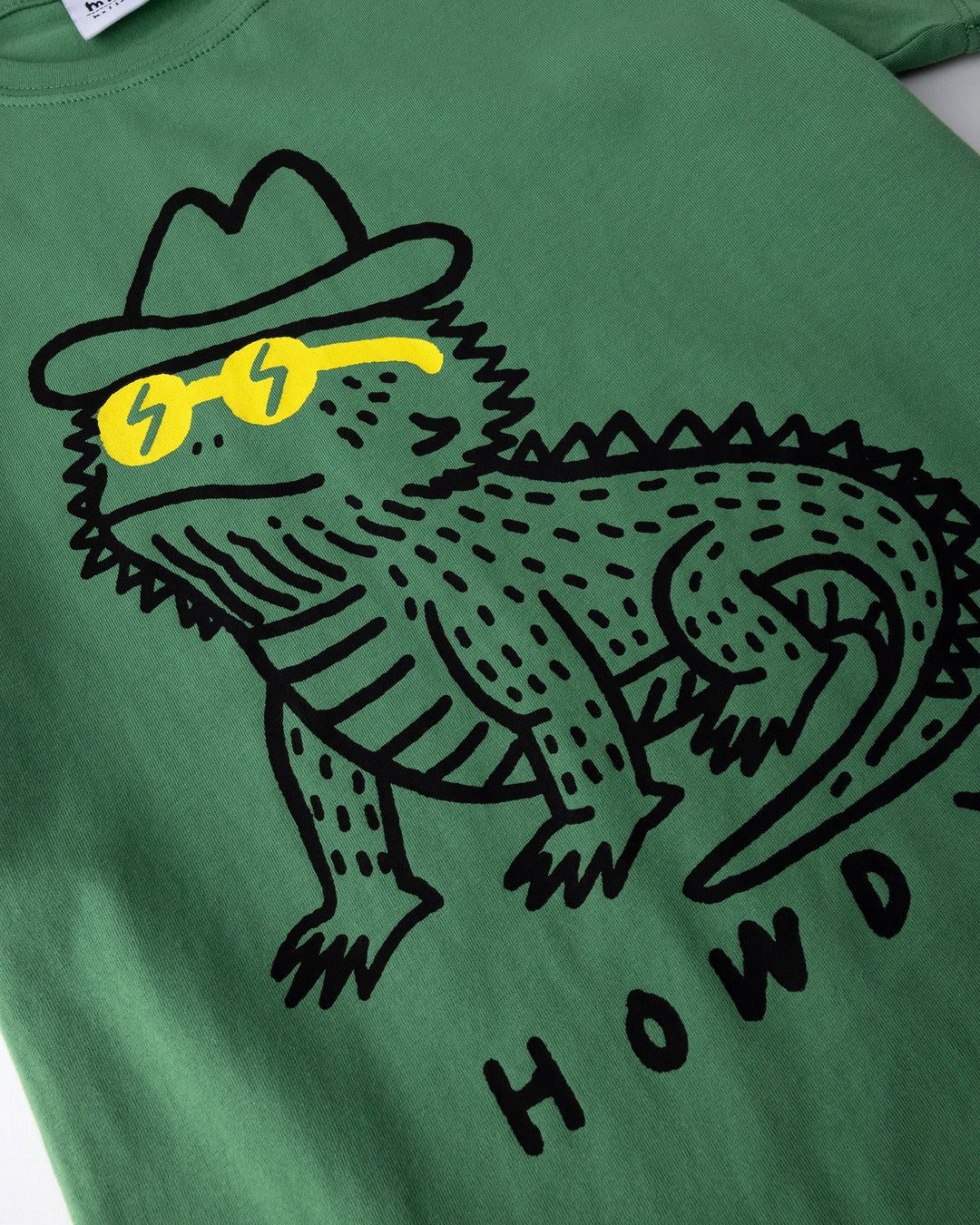Close up of the Howdy Lizard Tee print in turf