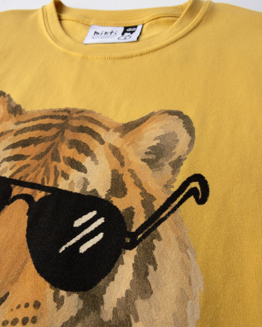 Close up of the Headphones Tiger Tee print in dull yellow