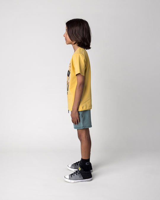 Kid wearing the Headphones Tiger Tee in dull yellow with the Blasted Track Short in forest wash, side view