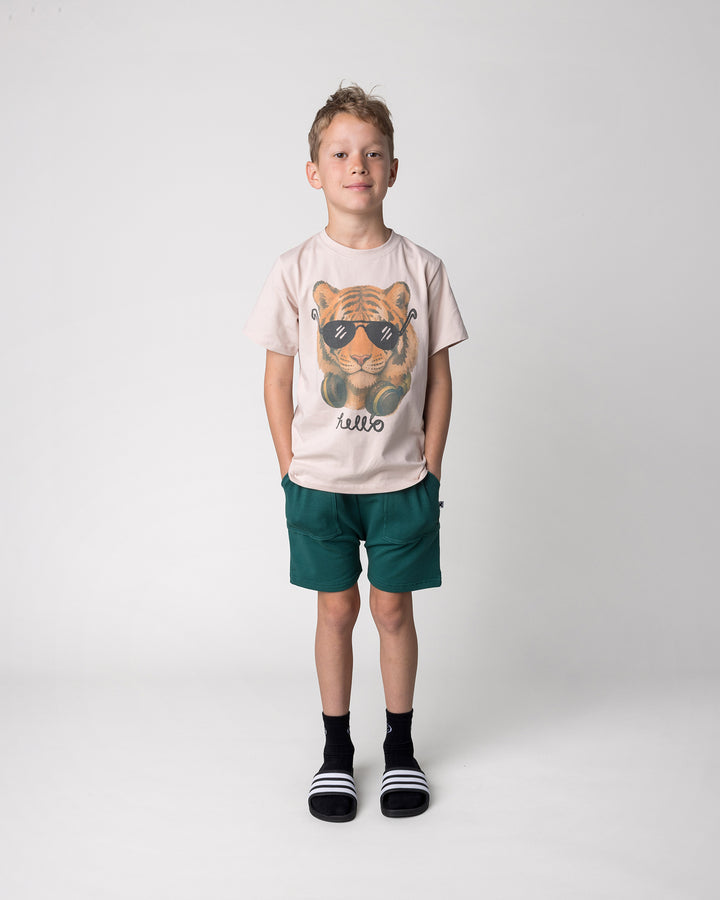 Kid wearing the Headphones Tiger Tee in stone with the Rib Pocket Short in kelly green, front view