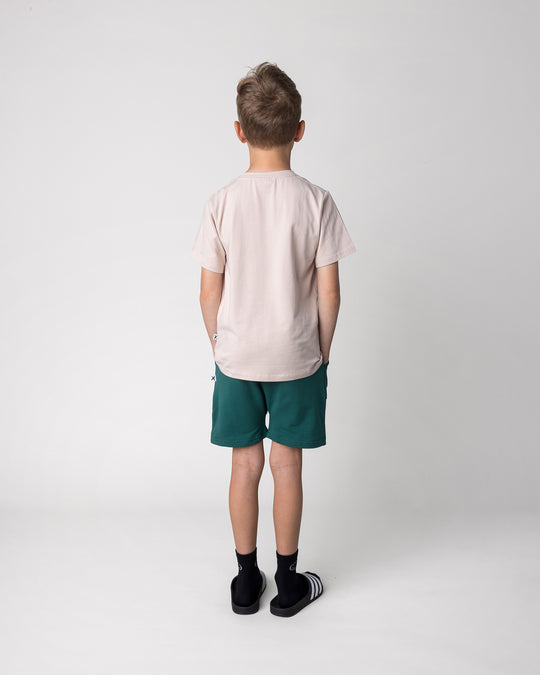 Kid wearing the Headphones Tiger Tee in stone with the Rib Pocket Short in kelly green, back view