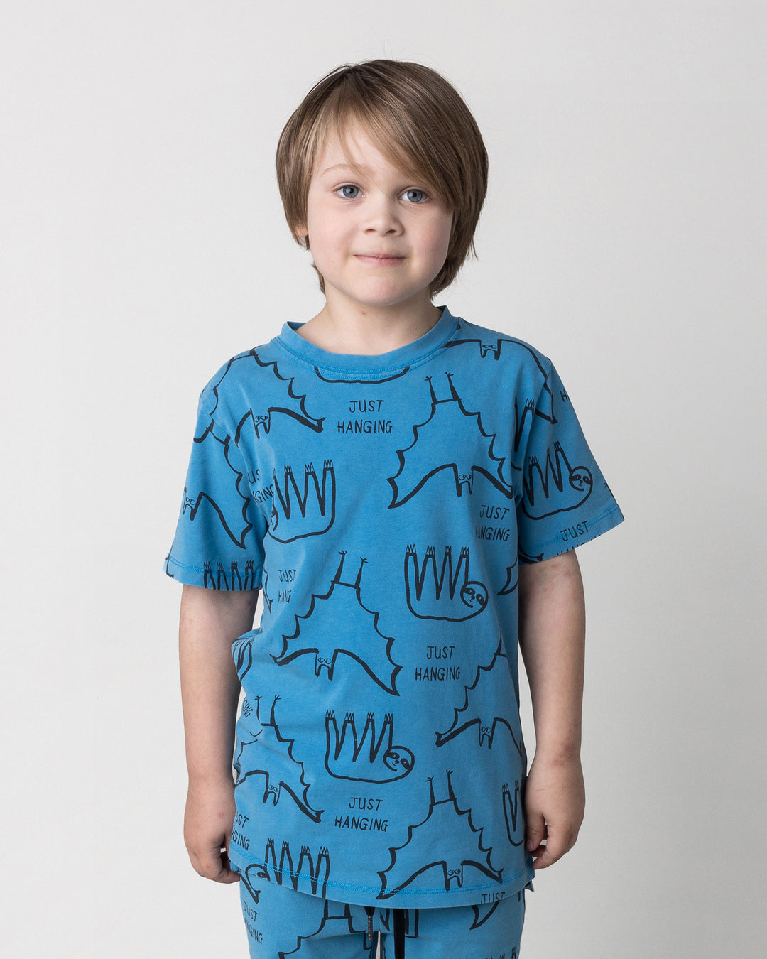 Close up of the Just Hanging Tee in sky wash on a kid, front view