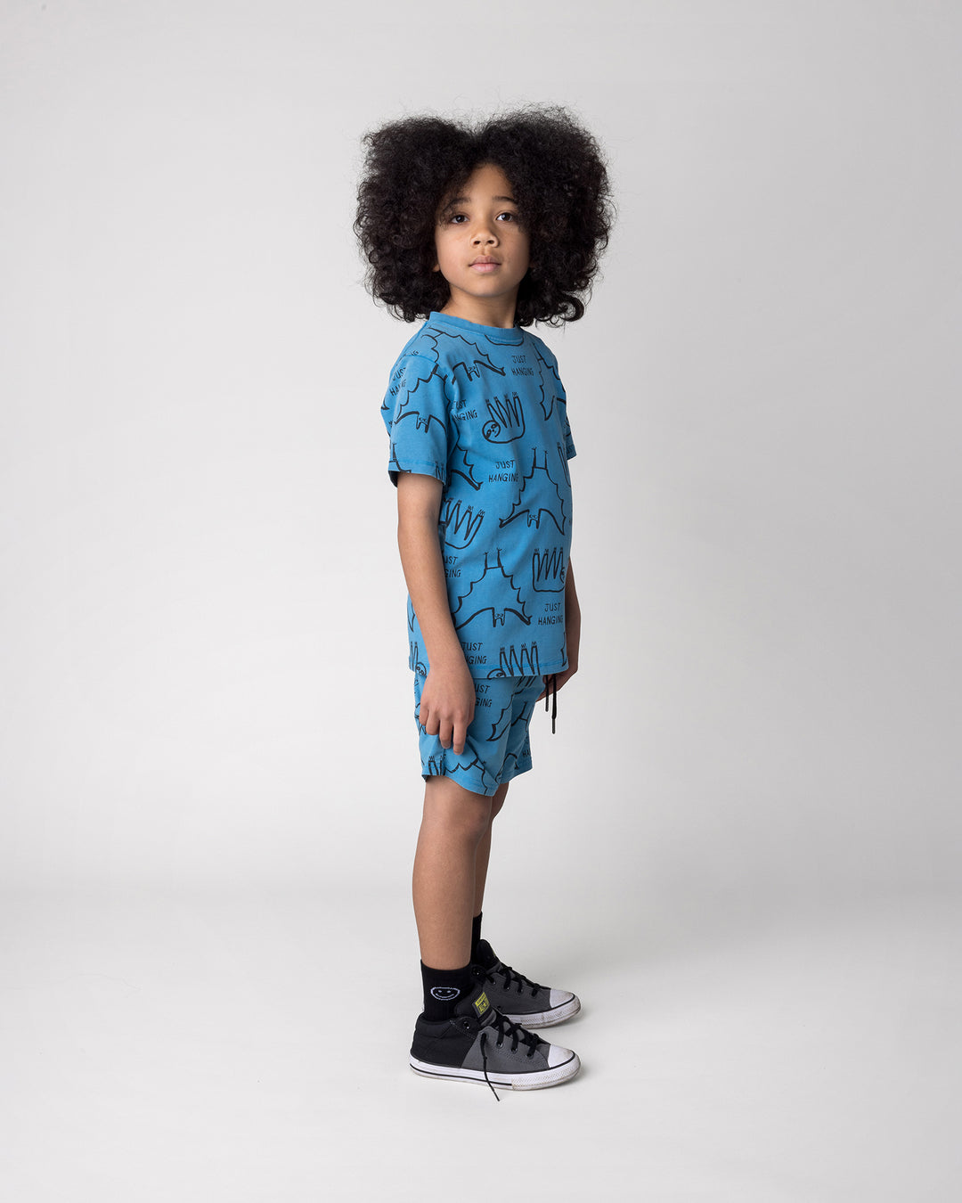 Kid wearing the Just Hanging Tee in sky wash with the Just Hanging Short in sky wash, side view