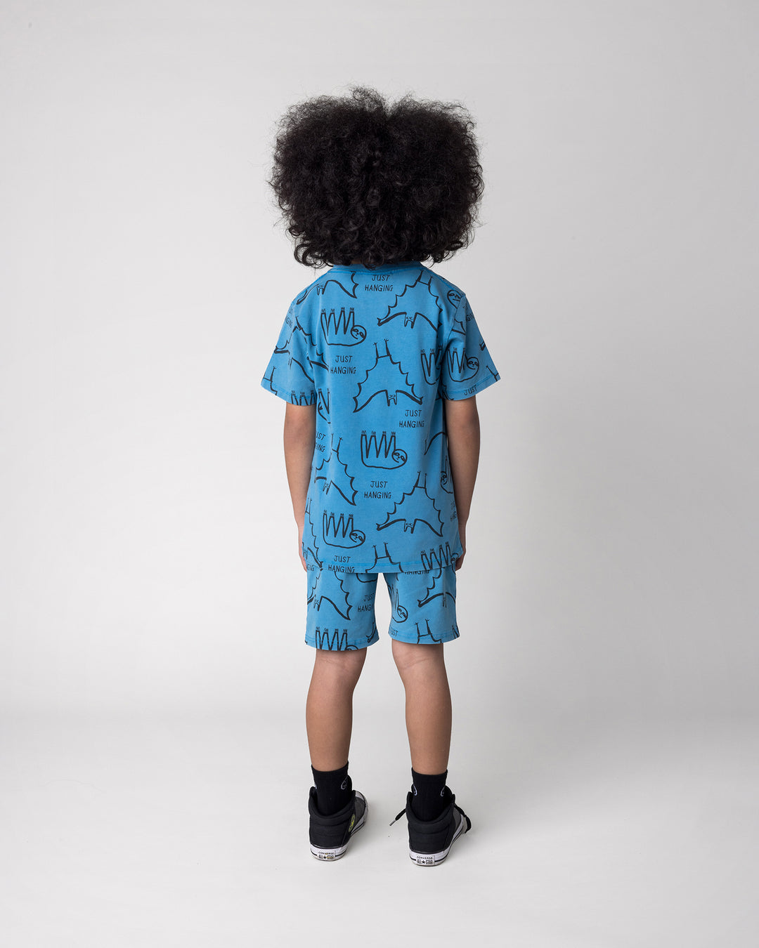 Kid wearing the Just Hanging Tee in sky wash with the Just Hanging Short in sky wash, back view