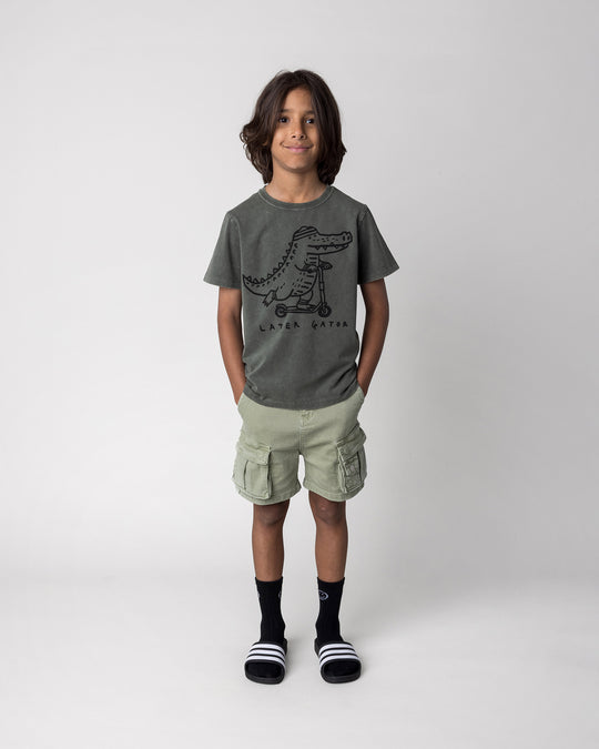 Kid wearing the Later Gator Tee in olive wash, front view