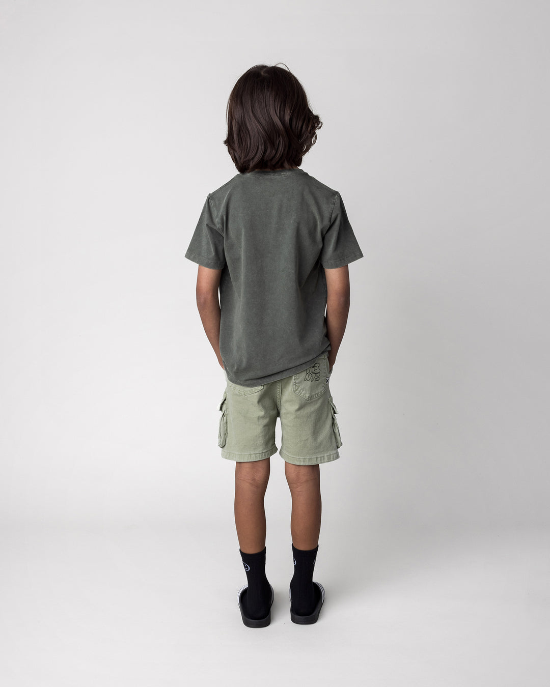 Kid wearing the Later Gator Tee in olive wash, back view
