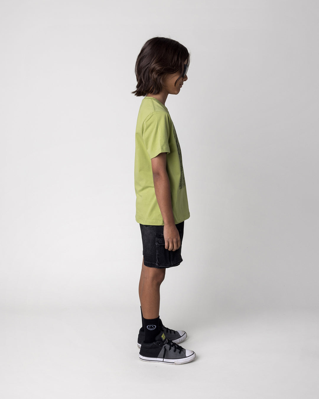 Kid wearing the Messy Monster Tee in lime, side view