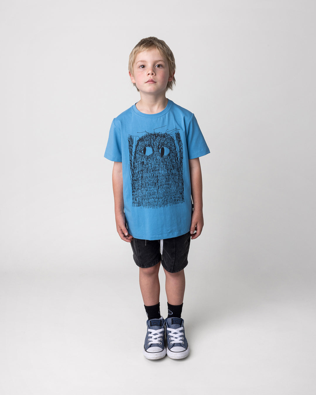 Kid wearing the Messy Monster Tee in steel with the Blasted Panel Short in black wash, front view