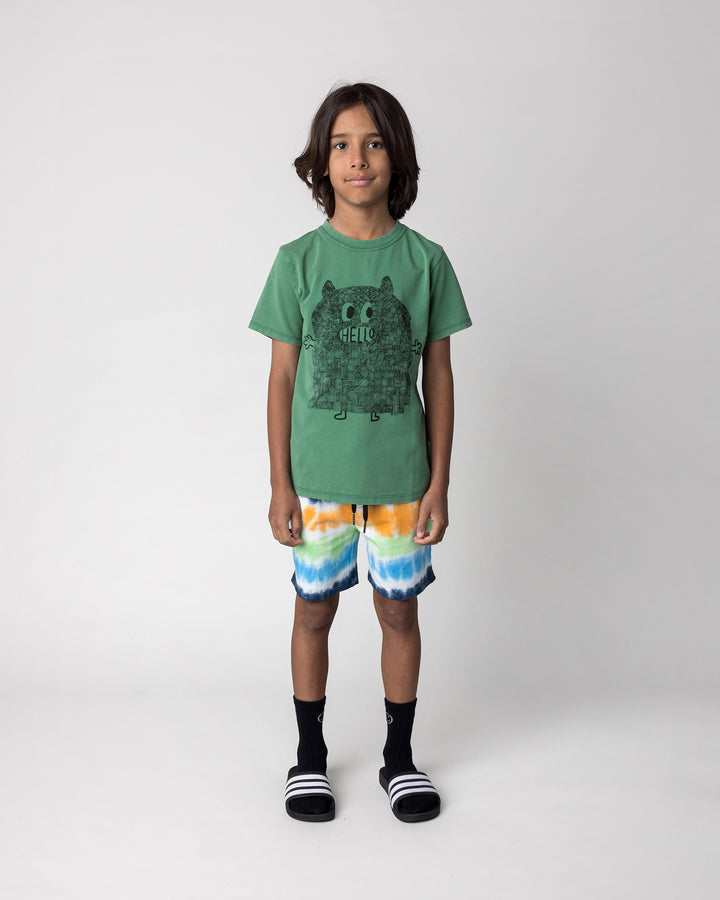Kid wearing the Patchwork Monster Tee in turf wash with the Airwaves Short in navy, front view