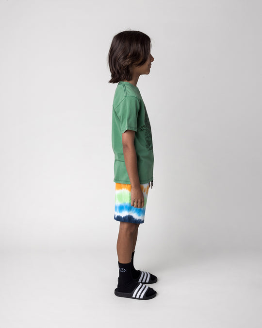 Kid wearing the Patchwork Monster Tee in turf wash with the Airwaves Short in navy, side view
